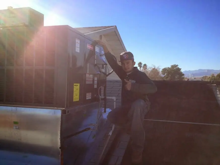 HVAC technician performing Boiler Repair on a rooftop unit in North Logan